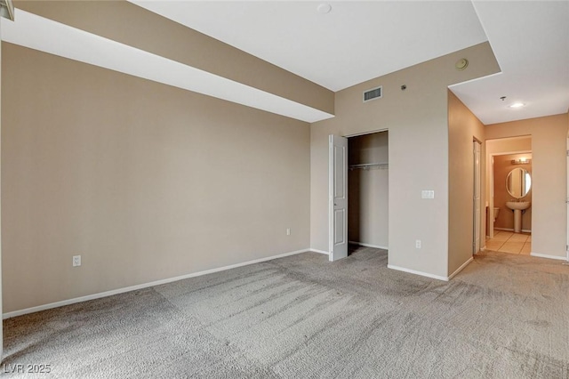 unfurnished bedroom featuring carpet floors, baseboards, visible vents, and a closet
