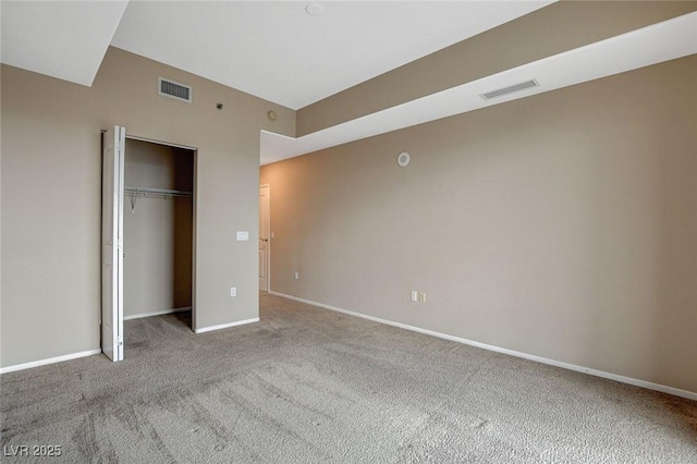 unfurnished bedroom with carpet floors, baseboards, visible vents, and a closet