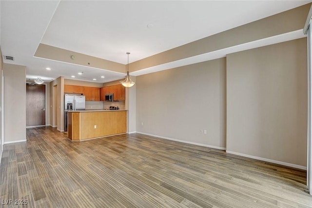 unfurnished living room featuring recessed lighting, baseboards, visible vents, and wood finished floors