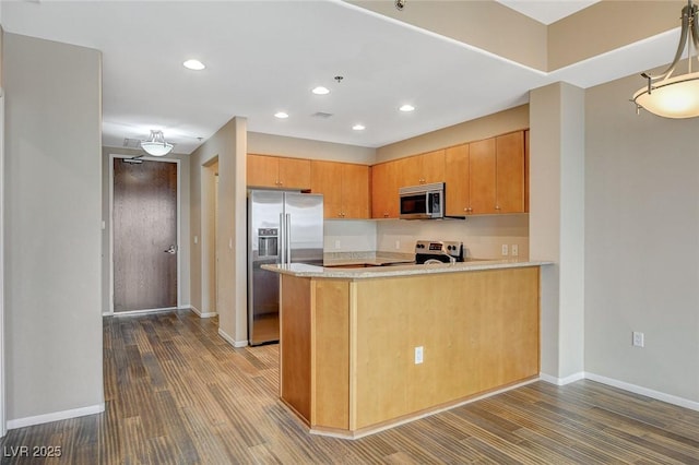 kitchen with baseboards, dark wood finished floors, a peninsula, and stainless steel appliances
