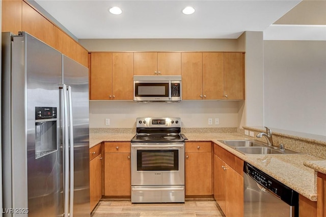 kitchen featuring light stone countertops, recessed lighting, a sink, light wood-style flooring, and stainless steel appliances