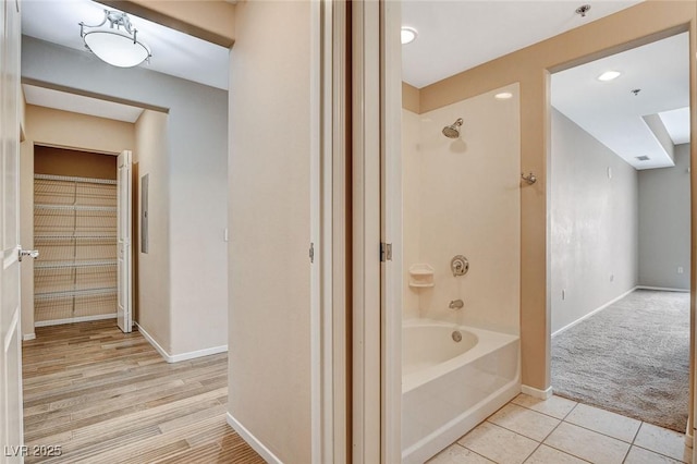bathroom with shower / bath combination and baseboards