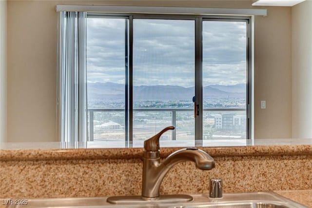 interior details with a sink, light stone counters, and a mountain view