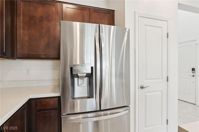 2877 Sweeping Palm Rd, North Las Vegas, NV 89086 - kitchen with stainless steel refrigerator with ice dispenser, dark brown cabinetry, and light countertops