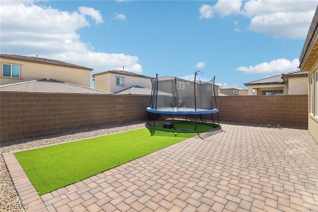 2877 Sweeping Palm Rd, North Las Vegas, NV 89086 - fenced backyard with a patio, a trampoline, and a residential view