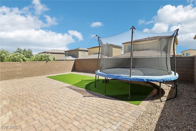 2877 Sweeping Palm Rd, North Las Vegas, NV 89086 - fenced backyard featuring a trampoline and a patio