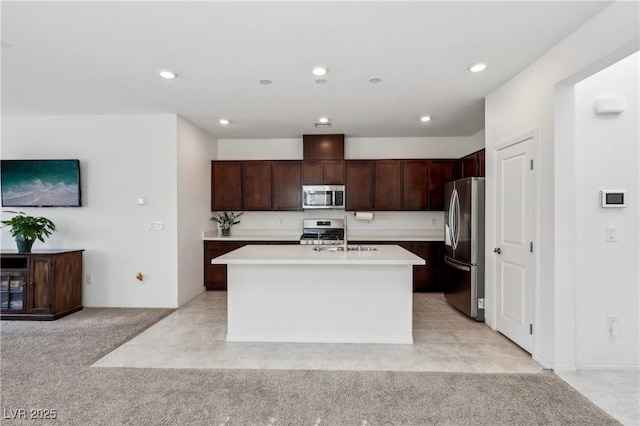 2877 Sweeping Palm Rd, North Las Vegas, NV 89086 - kitchen featuring appliances with stainless steel finishes, light countertops, a center island with sink, dark brown cabinets, and a sink