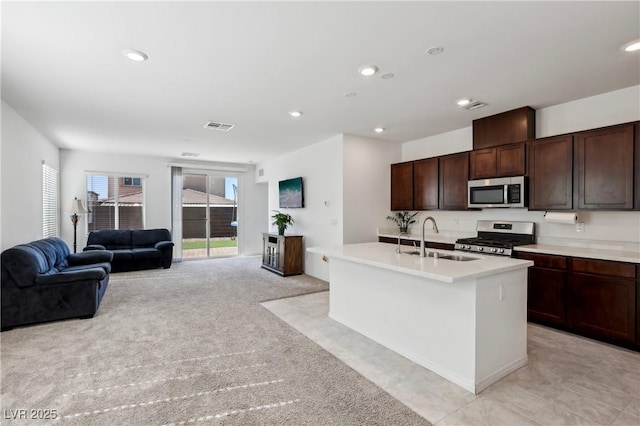 2877 Sweeping Palm Rd, North Las Vegas, NV 89086 - kitchen featuring stainless steel appliances, a sink, light countertops, open floor plan, and an island with sink