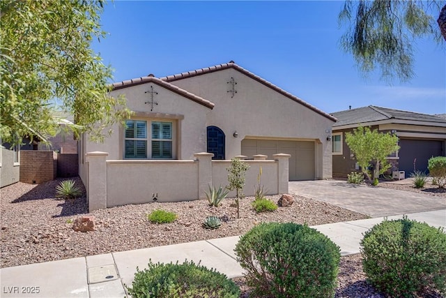 mediterranean / spanish-style home featuring stucco siding, an attached garage, driveway, and fence private yard