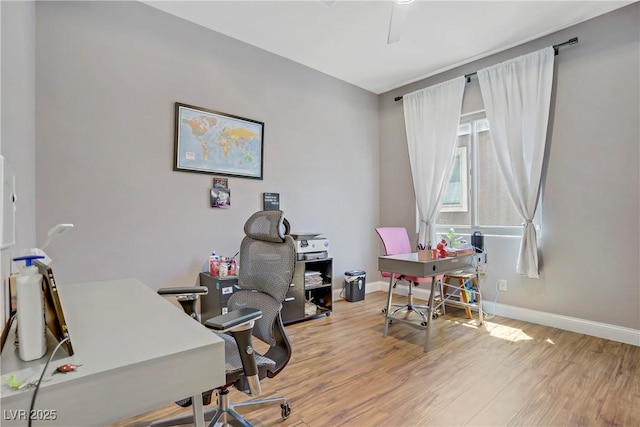 home office featuring wood finished floors, a ceiling fan, and baseboards