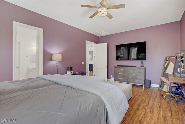 bedroom featuring visible vents, baseboards, a ceiling fan, wood finished floors, and connected bathroom