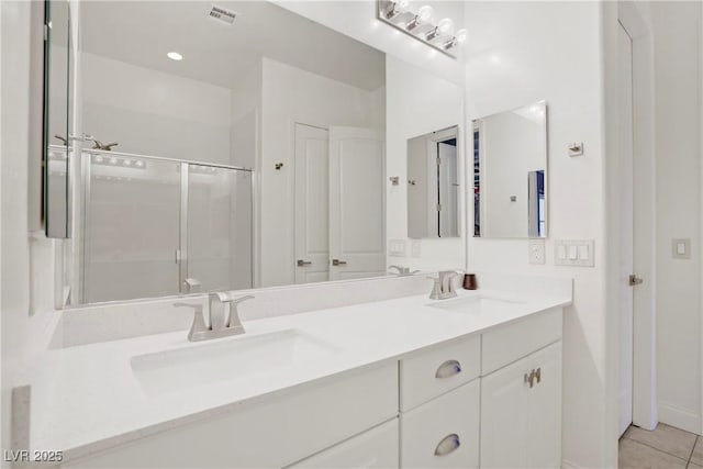 bathroom featuring double vanity, visible vents, tile patterned floors, and a sink