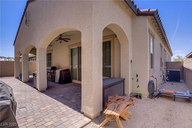 view of patio / terrace featuring ceiling fan, a fenced backyard, a hot tub, and central AC unit