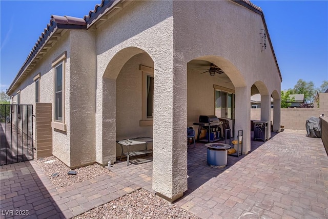 view of patio featuring grilling area, a gate, fence, and ceiling fan