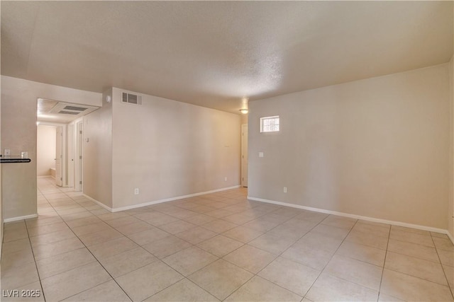 unfurnished room with light tile patterned floors, visible vents, and baseboards