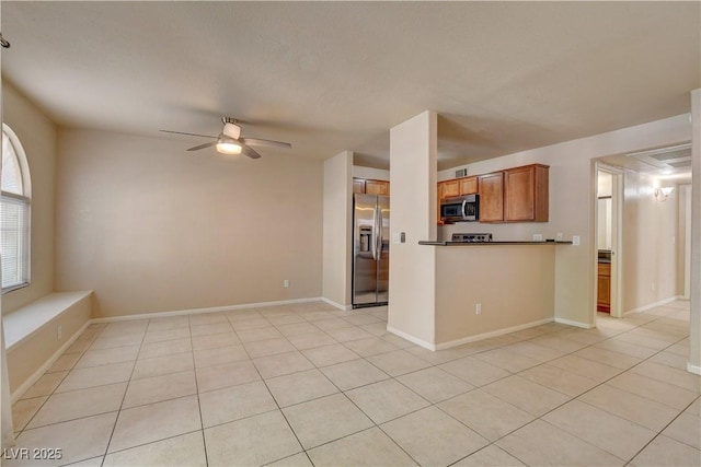 kitchen with brown cabinets, ceiling fan, appliances with stainless steel finishes, and open floor plan