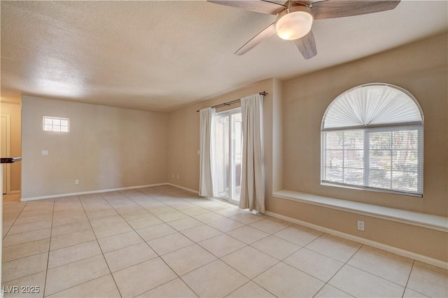 spare room with light tile patterned floors, ceiling fan, and baseboards