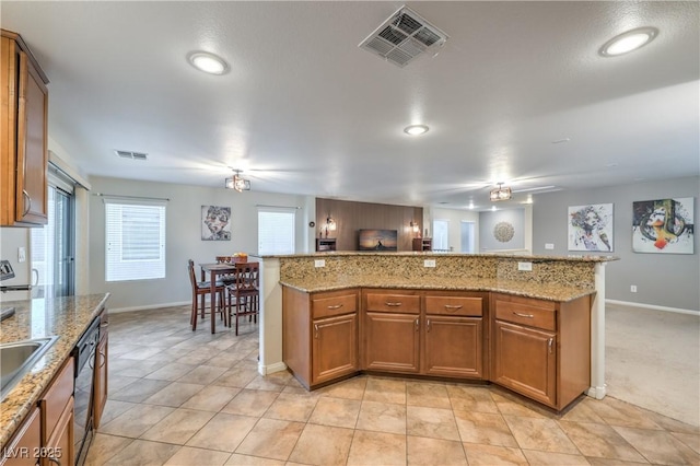 6546 American Flower St, Las Vegas, NV 89148 - kitchen with baseboards, black dishwasher, brown cabinetry, recessed lighting, and light stone countertops