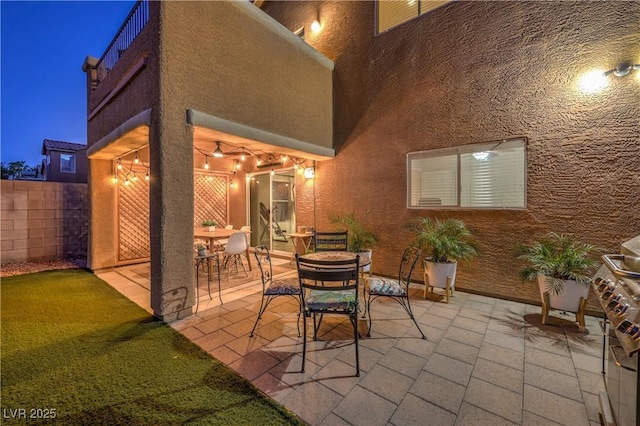 6546 American Flower St, Las Vegas, NV 89148 - patio at night with fence and outdoor dining area