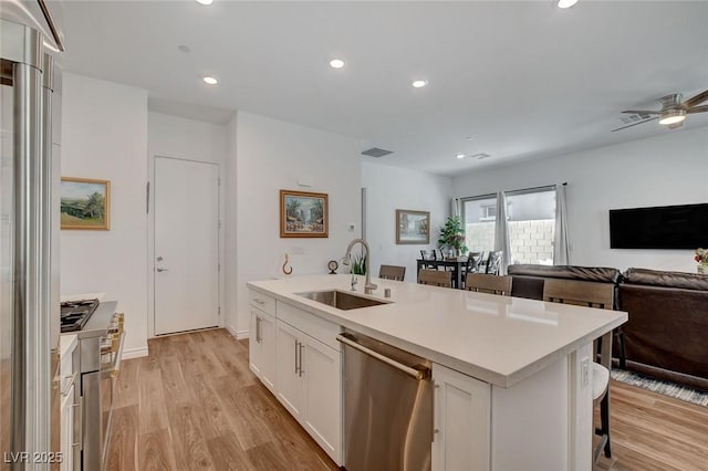 897 Woodburn Ln, Las Vegas, NV 89138 - kitchen featuring stainless steel appliances, open floor plan, light wood-type flooring, white cabinets, and recessed lighting