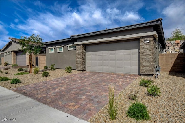 897 Woodburn Ln, Las Vegas, NV 89138 - view of front facade with decorative driveway, stucco siding, a garage, and stone siding