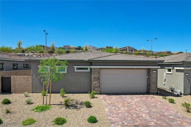 897 Woodburn Ln, Las Vegas, NV 89138 - view of front of property with a garage, decorative driveway, and stucco siding