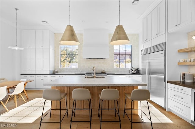10969 Tranquil Waters Ct, Las Vegas, NV 89135 - kitchen with stainless steel built in refrigerator, backsplash, plenty of natural light, and an island with sink