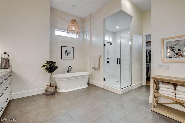 10969 Tranquil Waters Ct, Las Vegas, NV 89135 - full bath featuring a stall shower, a freestanding bath, vanity, tile patterned floors, and baseboards