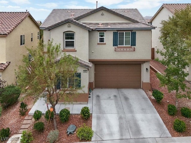 view of front of property featuring stucco siding, an attached garage, concrete driveway, and a tile roof