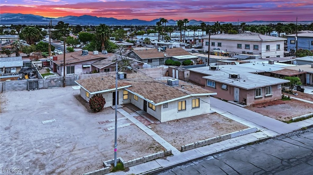 aerial view at dusk featuring a mountain view and a residential view