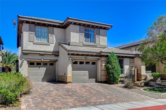 view of front of property with a garage, decorative driveway, and stucco siding