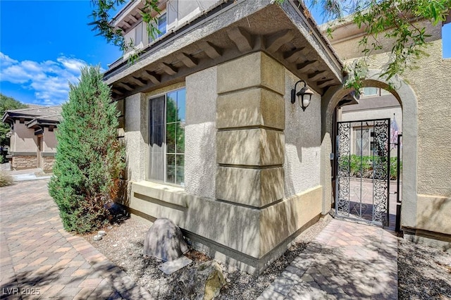 view of home's exterior with a gate and stucco siding
