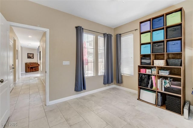 unfurnished room featuring healthy amount of natural light, baseboards, and light tile patterned floors