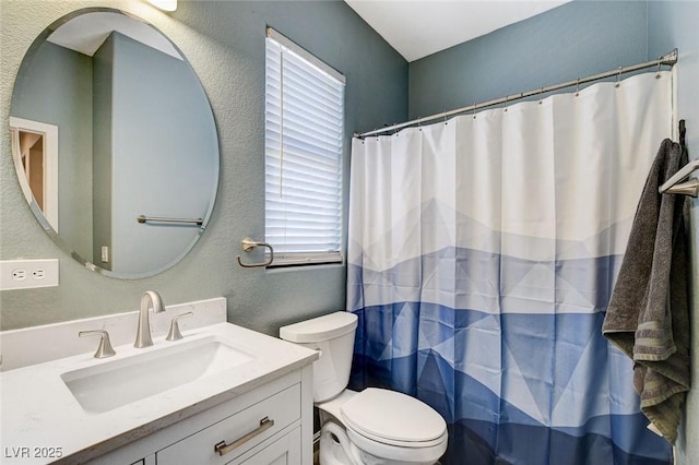 full bathroom featuring vanity, toilet, a textured wall, and curtained shower