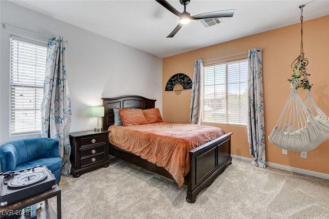 bedroom with light colored carpet, baseboards, and ceiling fan