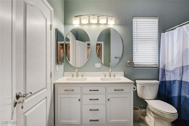 full bathroom with double vanity and toilet