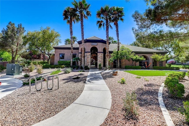 mediterranean / spanish-style house with stucco siding and stone siding