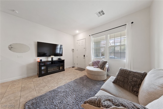 tiled living room with visible vents and baseboards