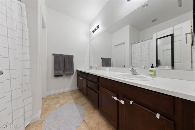 bathroom with double vanity, visible vents, tile patterned flooring, and a sink