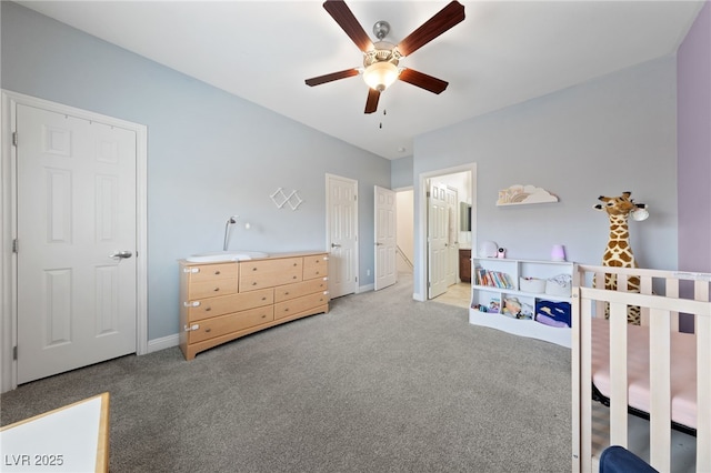 carpeted bedroom featuring ensuite bath, baseboards, and a ceiling fan
