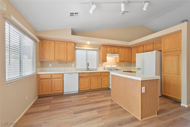 1805 Candle Bright Dr, Henderson, NV 89074 - kitchen featuring tile counters, white appliances, lofted ceiling, under cabinet range hood, and visible vents