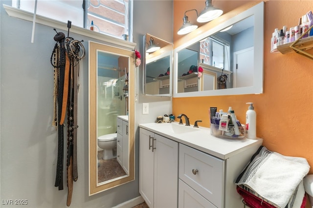 full bath featuring toilet, healthy amount of natural light, vanity, a shower, and a textured wall