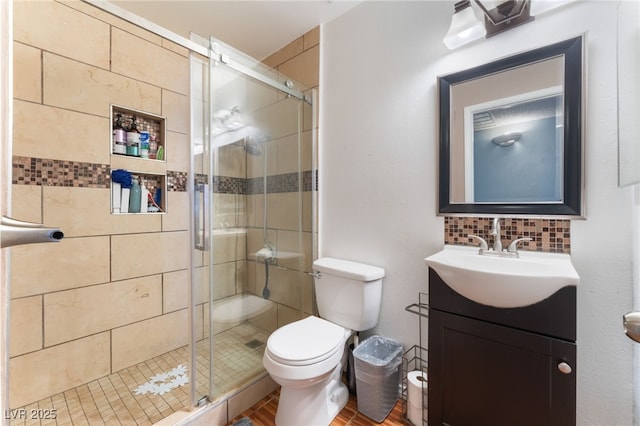 full bathroom featuring toilet, vanity, a shower stall, and decorative backsplash