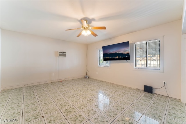 spare room featuring ceiling fan and an AC wall unit