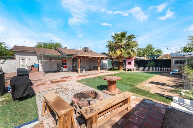 view of yard with a patio, a fire pit, and fence