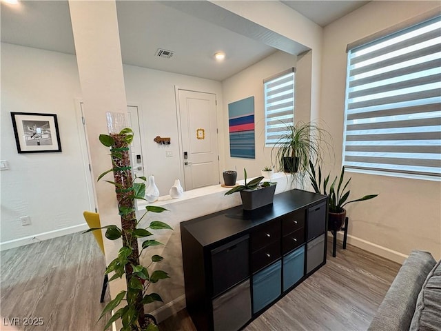 foyer entrance with wood finished floors and baseboards