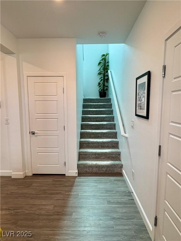 stairway featuring baseboards and wood finished floors
