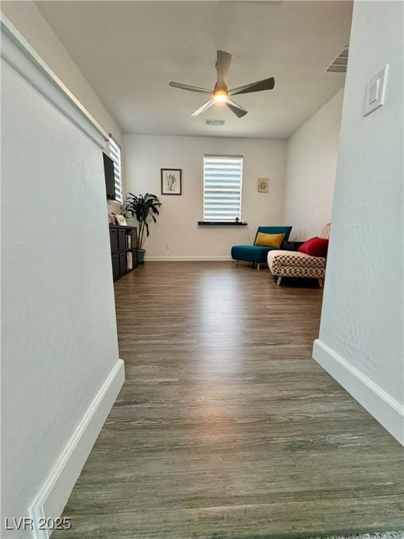 sitting room featuring a ceiling fan, baseboards, and wood finished floors
