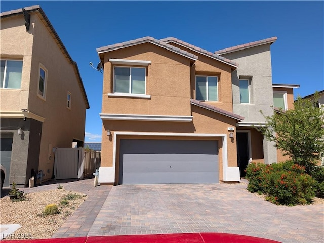 view of front of property featuring a tiled roof, an attached garage, and stucco siding