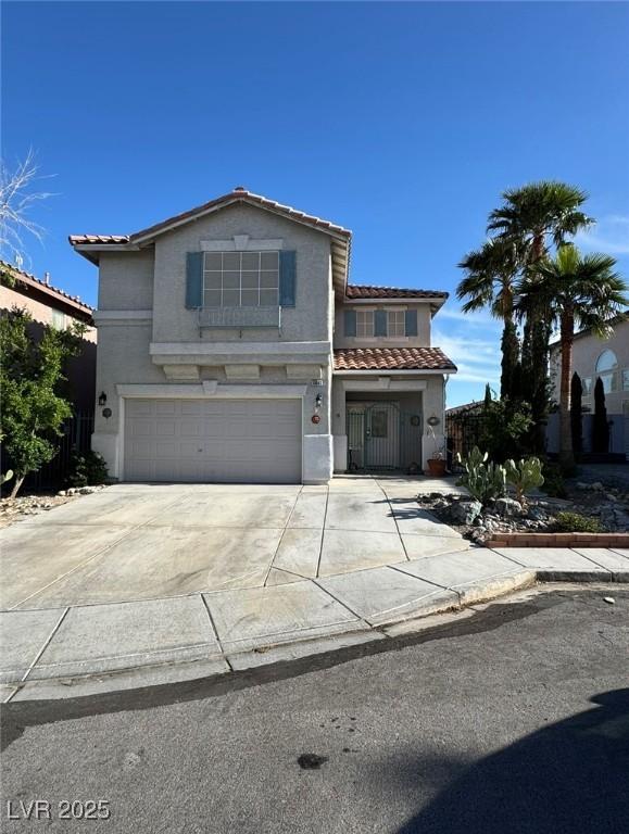 view of front of house featuring a garage, driveway, a tiled roof, stucco siding, and fence